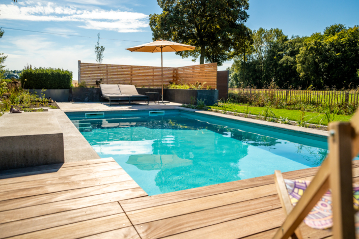 Pool im Garten mit türkisem Wasser und Sonne